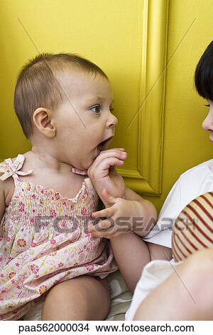 Infant girl holding on to brother's hand, cropped View Large Photo Image Picture - Infant girl holding on to brother's hand, cropped. Fotosearch