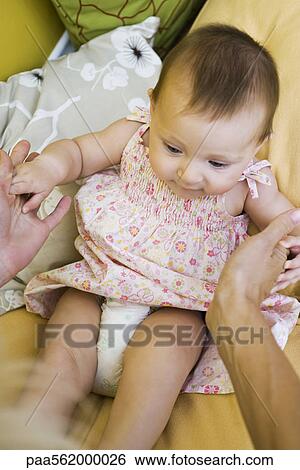 Infant girl sitting up with mother's help, cropped view View Large Photo Image Stock Photograph - Infant girl sitting up with mother's help, cropped view. Fotosearch