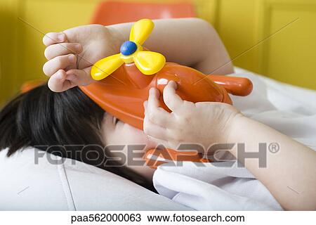 Little boy covering face with toy helicopter View Large Photo Image Stock Image - Little boy covering face with toy helicopter. Fotosearch