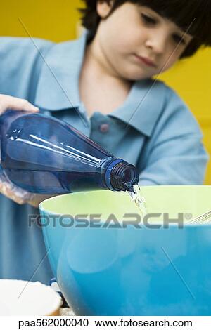 Little boy pouring bottled water into mixing bowl View Large Photo Image Stock Image - Little boy pouring bottled water into mixing bowl. Fotosearch