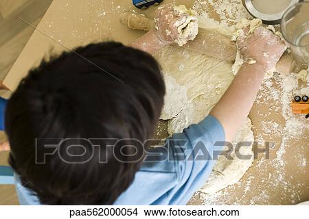 Little boy rolling out dough, overhead view View Large Photo Image Picture - Little boy rolling out dough, overhead view. Fotosearch