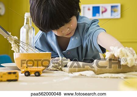 Little boy rolling out dough with rolling pin View Large Photo Image Stock Photo - Little boy rolling out dough with rolling pin. Fotosearch