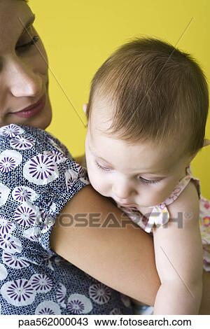 Stock Image - Mother holding infant, close-up. Fotosearch