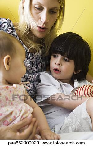 Mother holding infant daughter and son on lap, close-up View Large Photo Image Stock Photo - Mother holding infant daughter and son on lap, close-up. Fotosearch