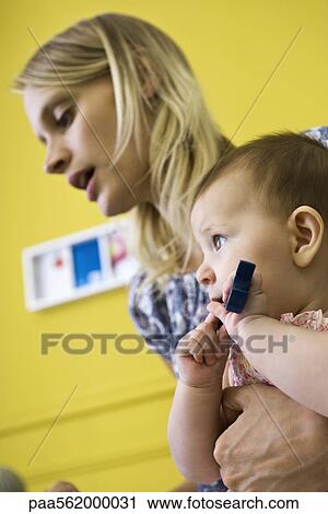 Mother holding infant daughter, side view View Large Photo Image Stock Image - Mother holding infant daughter, side view. Fotosearch
