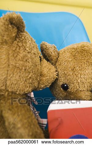 Stock Image - Teddy bear whispering into another teddy bear's ear. Fotosearch
