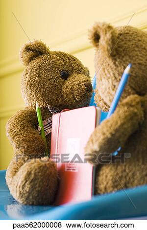 Stock Photo - Teddy bears placed face to face, holding colored pencils and book. Fotosearch