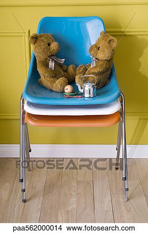 Teddy bears sitting face to face on stack of chairs View Large Photo Image Picture - Teddy bears sitting face to face on stack of chairs. Fotosearch