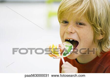 Boy eating lollipop View Large Photo Image Stock Image - Boy eating lollipop. Fotosearch