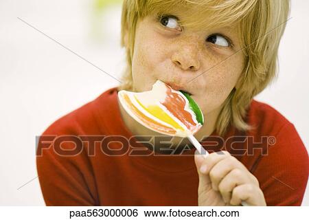 Boy eating lollipop View Large Photo Image Stock Photograph - Boy eating lollipop. Fotosearch