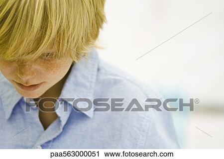Boy thoughtfully looking down View Large Photo Image Stock Image - Boy thoughtfully looking down. Fotosearch