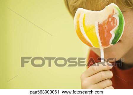 Child holding up lollipop View Large Photo Image Stock Image - Child holding up lollipop. Fotosearch