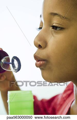Stock Image - Girl blowing bubbles. Fotosearch