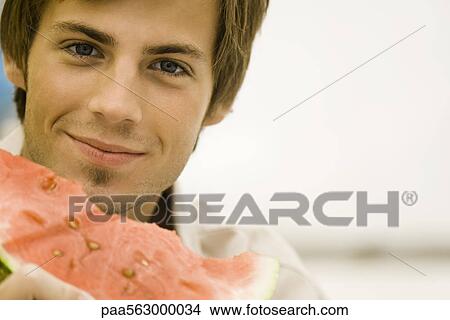 Picture - Man holding slice of watermelon. Fotosearch