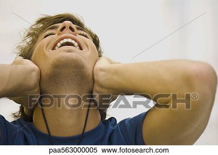 Man listening to headphones, leaning head back smiling View Large Photo Image Stock Photography - Man listening to headphones, leaning head back smiling. Fotosearch