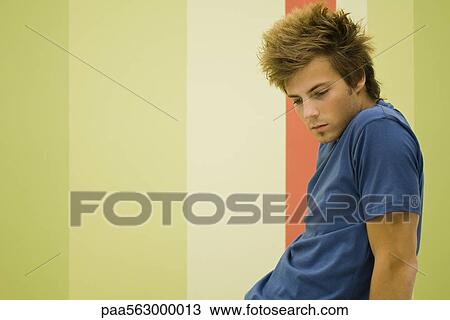 Young man looking down in thought View Large Photo Image Stock Image - Young man looking down in thought. Fotosearch