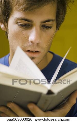 Young man reading book, close-up View Large Photo Image Stock Photograph - Young man reading book, close-up. Fotosearch