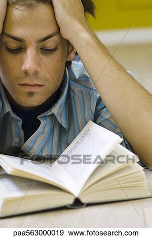 Stock Photo - Young man reading book. Fotosearch