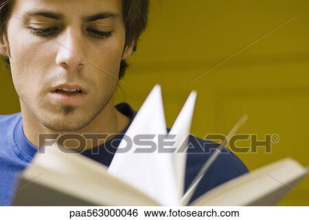 Young man reading book View Large Photo Image Stock Photograph - Young man reading book. Fotosearch