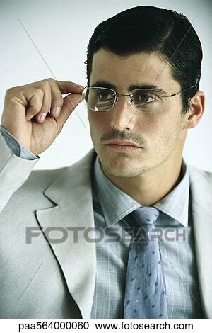 Businessman adjusting glasses, portrait View Large Photo Image Stock Image - Businessman adjusting glasses, portrait. Fotosearch