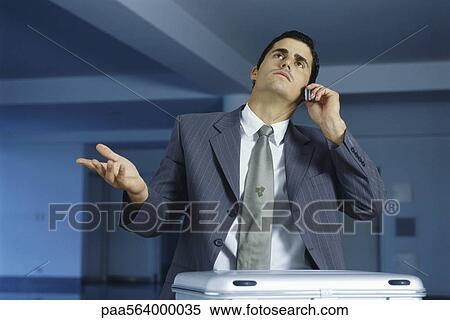 Businessman talking on cell phone, making frustrated gesture with hand View Large Photo Image Stock Photography - Businessman talking on cell phone, making frustrated gesture with hand. Fotosearch