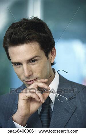 Businessman with holding glasses in hand, portrait View Large Photo Image Stock Image - Businessman with holding glasses in hand, portrait. Fotosearch