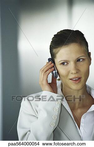 Businesswoman using cell phone, glancing sideways View Large Photo Image Picture - Businesswoman using cell phone, glancing sideways. Fotosearch