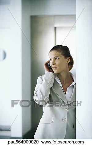Businesswoman using cell phone, glancing away View Large Photo Image Stock Image - Businesswoman using cell phone, glancing away. Fotosearch