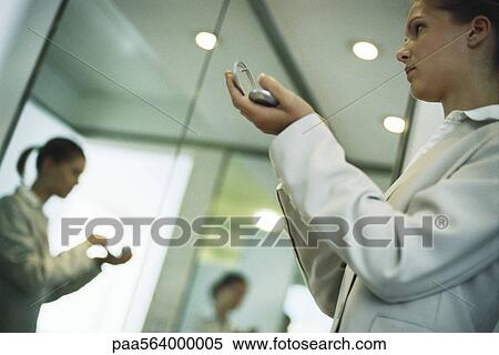 Woman holding powder compact putting on makeup, low angle view View Large Photo Image Stock Photography - Woman holding powder compact putting on makeup, low angle view. Fotosearch