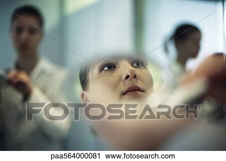Woman putting on makeup, close-up of reflection in powder compact mirror View Large Photo Image Stock Image - Woman putting on makeup, close-up of reflection in powder compact mirror. Fotosearch