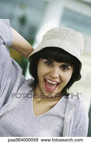 Stock Photo - Woman smiling with looking of astonishment, portrait. Fotosearch