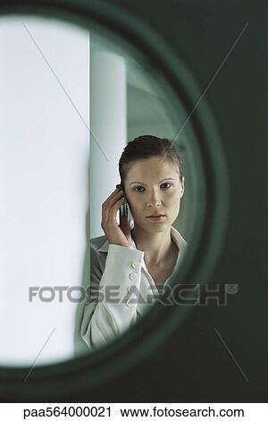 Woman using cell phone seen through door window View Large Photo Image Stock Image - Woman using cell phone seen through door window. Fotosearch