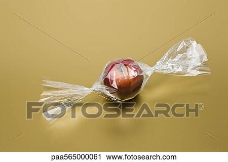 Food concept, fresh apple inside cellophane candy wrapper View Large Photo Image Stock Image - Food concept, fresh apple inside cellophane candy wrapper. Fotosearch