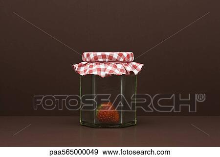 Stock Photo - Food concept, single fresh strawberry inside glass jar. Fotosearch