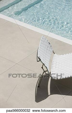 Stock Image - Chair at edge of shallow pool. Fotosearch