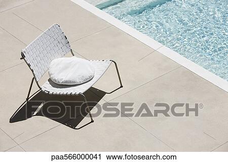 Chair with cushion at edge of pool View Large Photo Image Stock Image - Chair with cushion at edge of pool. Fotosearch