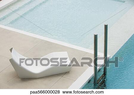 Poolside deckchair near deep end ladder View Large Photo Image Stock Photo - Poolside deckchair near deep end ladder. Fotosearch