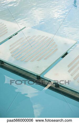 Stock Photograph - Stepping stones leading across swimming pool. Fotosearch