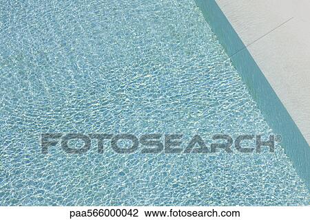Stock Image - Sunlight refracted on water in swimming pool. Fotosearch