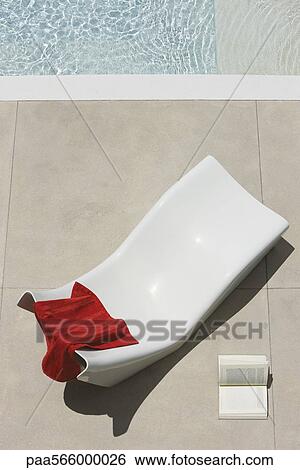 Towel left on poolside deckchair, open book lying on ground nearby View Large Photo Image Stock Photograph - Towel left on poolside deckchair, open book lying on ground nearby. Fotosearch