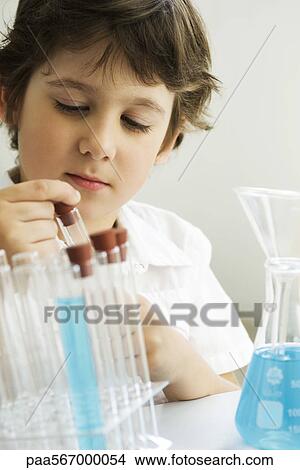 Boy placing test tube into test tube rack View Large Photo Image Picture - Boy placing test tube into test tube rack. Fotosearch