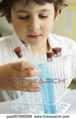 Stock Photo - Boy placing test tubes in test tube rack. Fotosearch