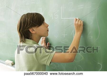 Stock Image - Boy writing on blackboard. Fotosearch