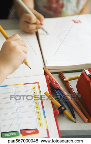 Children writing in notebooks, school supplies nearby, cropped View Large Photo Image Stock Photo - Children writing in notebooks, school supplies nearby, cropped. Fotosearch