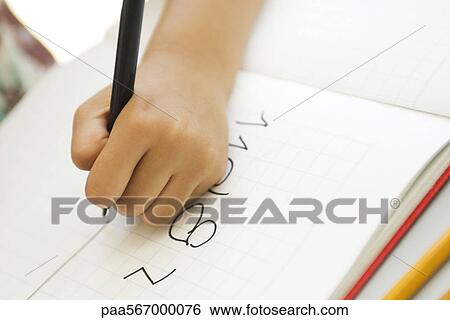 Stock Photograph - Child's hand writing in notebook. Fotosearch