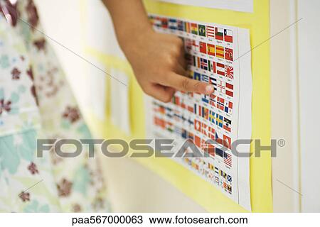 Stock Image - Elementary student pointing to flag on chart, cropped. Fotosearch