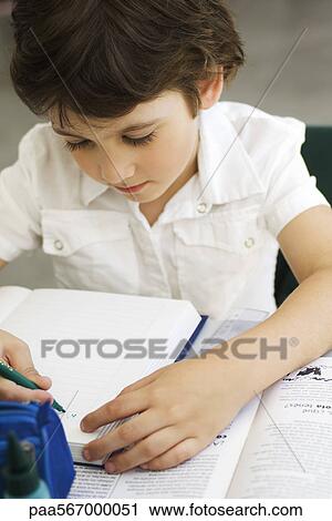 Stock Image - Elementary student working on assignment. Fotosearch