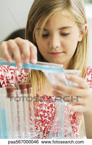 Stock Photograph - Girl transferring liquid from test tube to beaker. Fotosearch