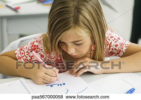 Stock Photo - Girl working math equation in notebook. Fotosearch