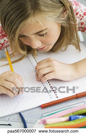 Girl writing in notebook, high angle view View Large Photo Image Stock Photo - Girl writing in notebook, high angle view. Fotosearch